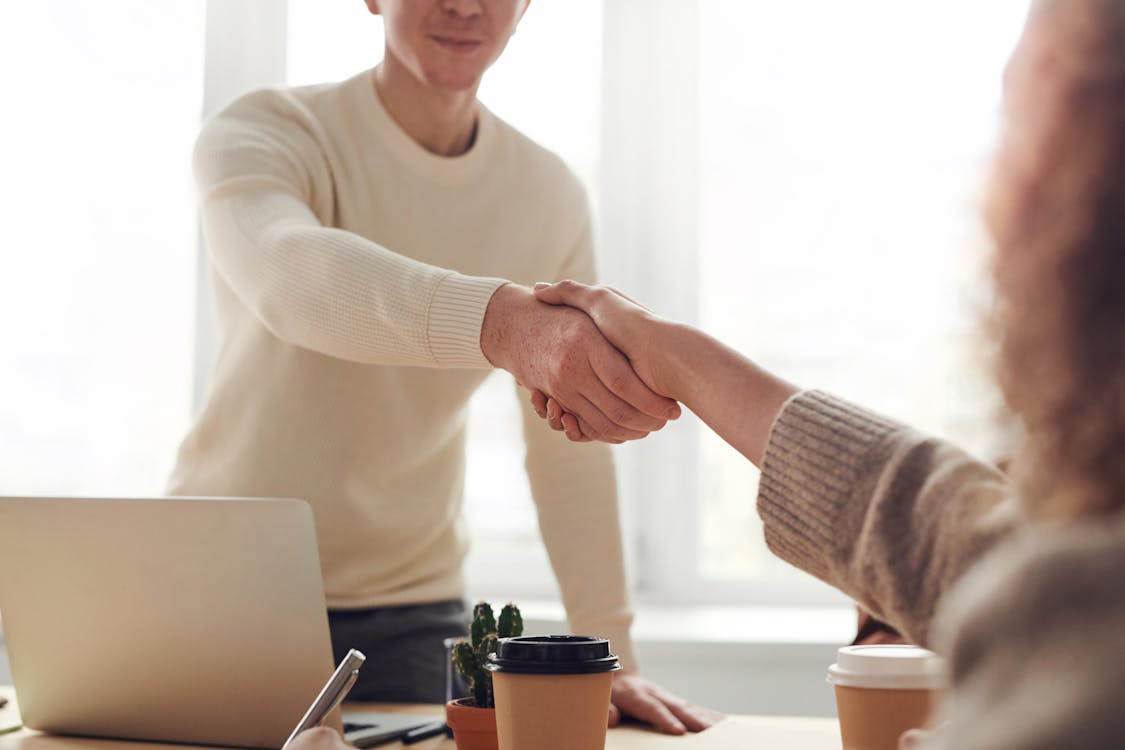 An empowered homeowner smiles confidently in their clean, minimalist kitchen, representing the peace of mind that comes from a data-driven home selling process.