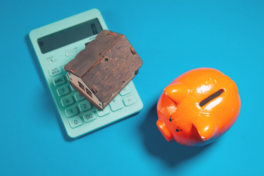 A professionally dressed person uses a calculator next to a miniature house model, representing the smart financial planning involved in maximizing home sale profits.