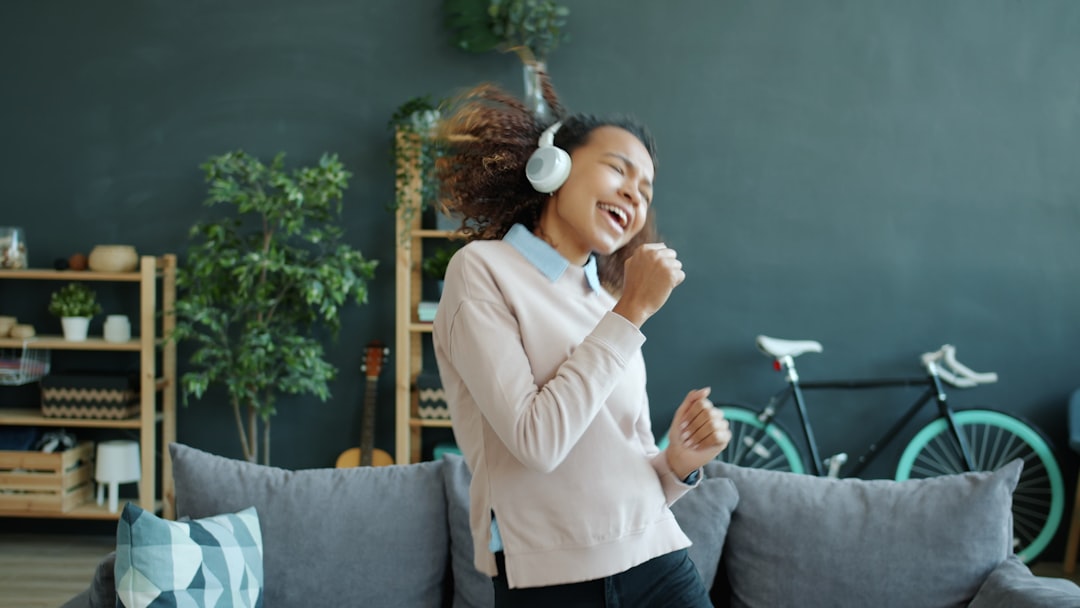 A smiling homeowner proudly holds up a set of new keys inside a bright, modern living room, representing a successful and profitable home sale.