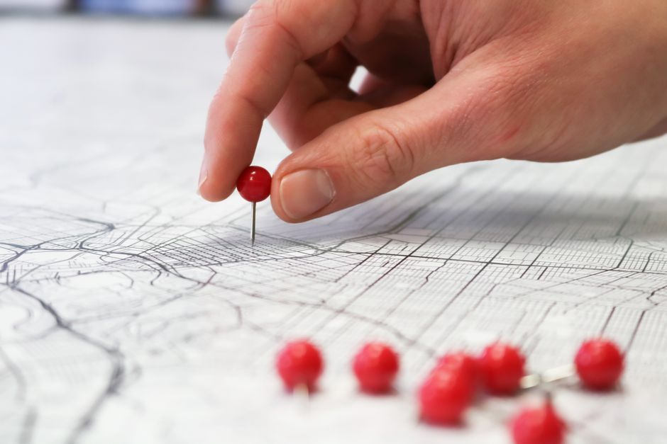 A close-up of a real estate agent's hands pointing to specific details on an architectural blueprint, symbolizing navigating property law and zoning.
